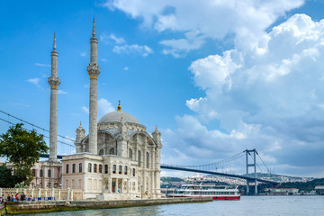 Fototapeta na wymiar Istanbul landscape. Istanbul's populer touristic destination Ortakoy Mosque and Bosphorus Bridge view. Cloudy sky in summer day
