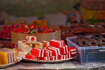 Turkish national sweets are sold at the fair. Multi-colored Asian desserts stacked on the table. Rahat lokum in bulk is sold at the festival.