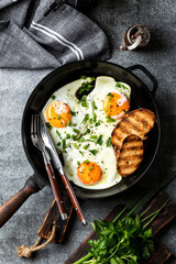 fried eggs in a cast iron pan top view