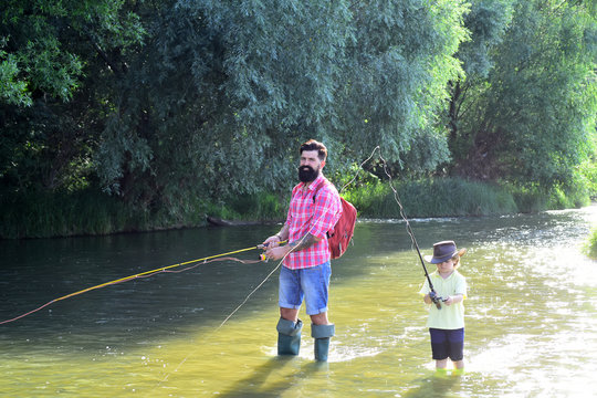 Father and son fishing. Father and son relaxing together. Little boy fishing with father.