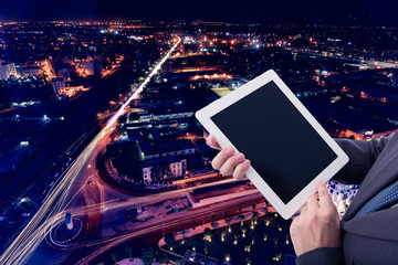 Businessman with computer tablet on hand with night city background