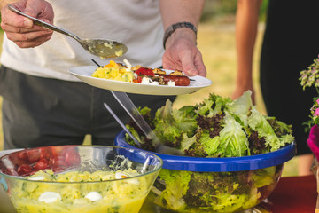 grilling in the garden, a person holds a plate of food in his hand