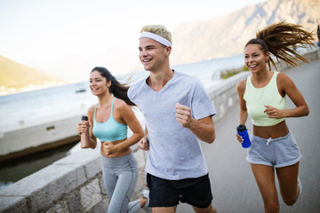 Group of young people jogging and running outdoors in nature