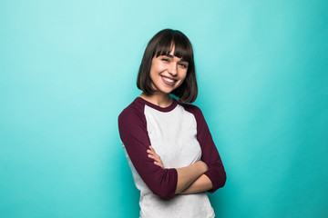 Portrait of the beautiful young woman with crossed hands on the green background