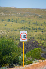 Speed limit 110 kph street sign next to Australian road