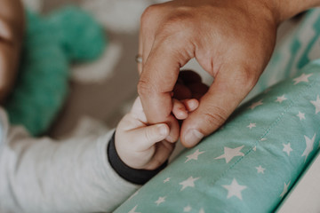 Newborn baby holding hand