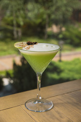 cocktail with cream, cinnamon, Apple slice in a beautiful glass on the background of nature