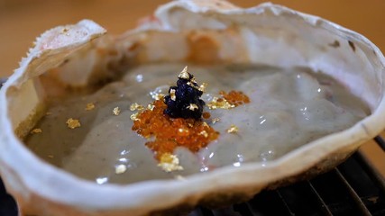 Zoom in of Kani Miso, crab miso, crab fat boiling / grill on the stove at the restaurant (Japanese Food)