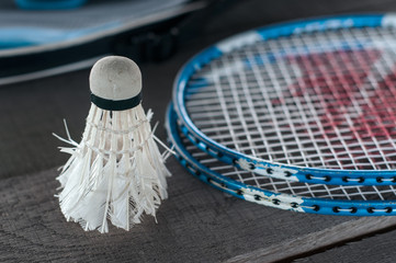 Badminton racket and bollard on an old wooden surface. Badminton retro style. Entertainment at the picnic.