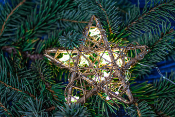 Fototapeta na wymiar Christmas tree branches with a luminous star.