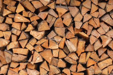 Preparation of firewood for the winter. Firewood background, Stacks of firewood in the forest. Pile of firewood.