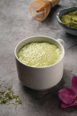 Latte matcha coffee. Japanese matcha green tea powder, a healthy natural product, antioxidant. Gray background, close-up, copy space.
