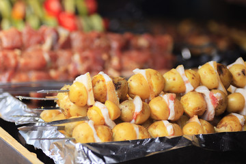 Street food. Potato skewers with bacon.