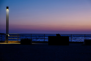 Syracuse, Ortegia, Sicily, Italy A couple watch the sunrise.