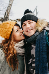 The happy couple in love making selfie at forest nature park in cold season. Travel adventure love story