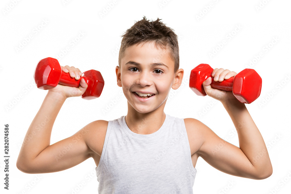 Wall mural cheerful boy athlete raised his hands with red dumbbells, performs exercises and smiles, leader, on 