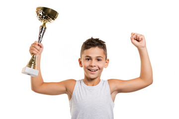 winner or leader concept, boy with a sports cup in his hand, raised his hands and smiling, joy of...
