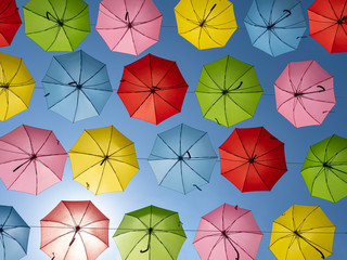 Many multicolored umbrellas against the blue sky.