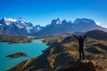Hiker at mirador condor enjoying amazing view of Los Cuernos rocks and Lake Pehoe in Torres del Paine national park, Patagonia, Chile - obrazy, fototapety, plakaty