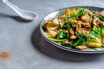 Close up pan-asian thai salad bowl. Flat lay food on grey stone background. Warm salad with veal, spinach, mushrooms and spices. Copy space. Banner, menu, poster photo