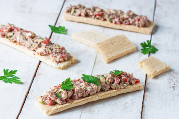 tuna salad with vegetables and boiled egg on  crispbread healthy open sandwiches on white table