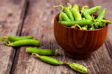 Green peas in a wooden bowl.