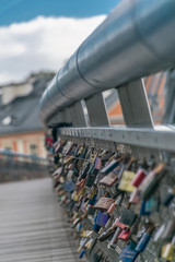 Vertical view of Romantic Padlocks with the name of the couple, attached to a bridge, representing the durability of their eternal love.