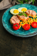 Breakfast snack, tasty food (pate, toast, tomato, corn, egg, coffee). top view. food background