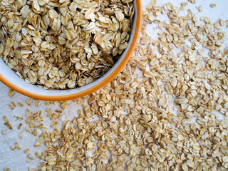 Oat groats or oat spike in wooden plate on homespun tablecloth, copy space, top view, selective focus