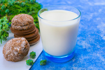 Glass of milk with cookies on the table. On a light blue background.