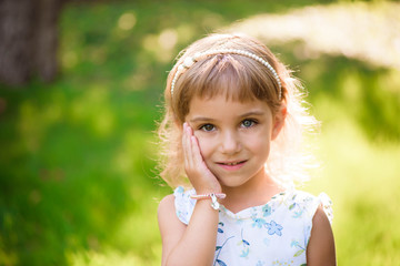 Sweet, happy, smiling five year old girl laying on a grass