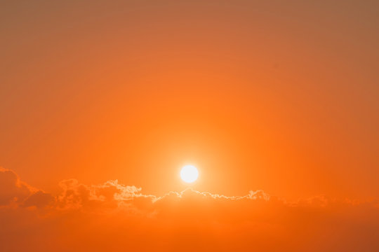 Fiery orange sunset sky. Beautiful sky. strong sunrise with silver lining and cloud on the orange sky