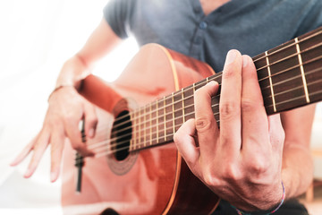 Obraz na płótnie Canvas man's hands playing acoustic guitar, close up