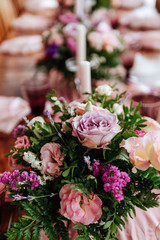 Vintage festive table setting with pink roses, candles and cutlery on an old wooden board