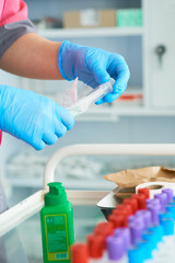 Nurse holding a medical syringe in hand and prepare to putting medicine inside it. Injection preparation in hospital.