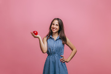 Girl holding red Apple on pink background
