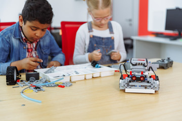 Mixed Racial group of School kids sitting at class with diy robot, stem education concept.