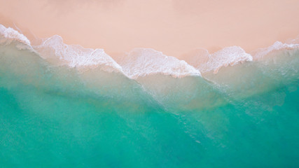 Fototapeta na wymiar Beach top view. Aerial view sand beach wave foam from turquoise water on the tropical island