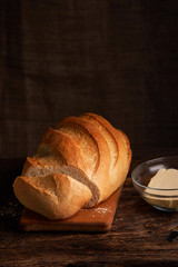 Woman cuts bread on wooden desk, concept of home food close up