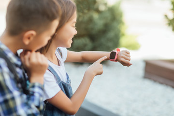 Learning new technology. Close up photo, child plkay with smartwatch.