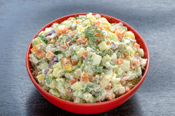 Healthy homemade russian traditional salad olivier ready to eat, close up
