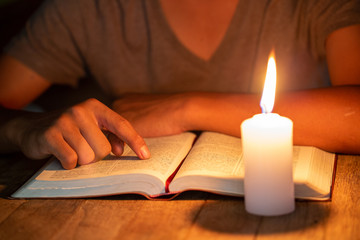 close up of Christian boys  are reading and study bible In the room and lit candles to light, Religious concepts