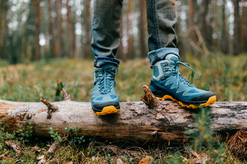 Male legs wearing sportive hiking shoes outdoor. Mens legs in trekking boots for outdoor activity