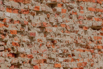 front view of the cracked red clay brick wall of a residential building