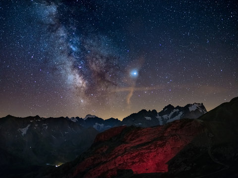 Milky Way and starry sky on the Alps, Massif des Ecrins, Briancon Serre Chevalier ski resort, France. Panoramic view high mountain range and glaciers, astro photography, stargazing. Planet Jupiter