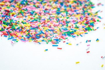 Colorful candy sprinkles close up for birthday cake on white background