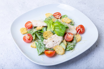Caesar (cesar) salad with chicken, crackers, parmesan and cherry tomatoes. Close-up.