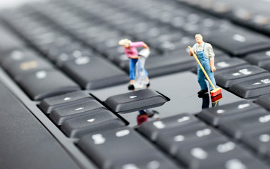 miniature office cleaner on a keyboard 