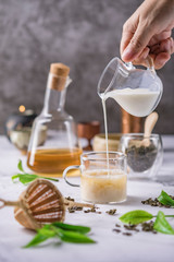 Hot tea in glass teapot and cup with steam on dark background.