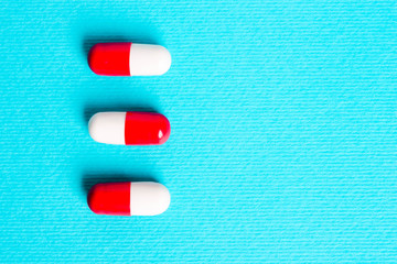 White red capsules, pills on a blue background.